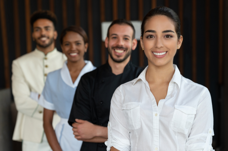 A group of hotel staff smiles into the camera